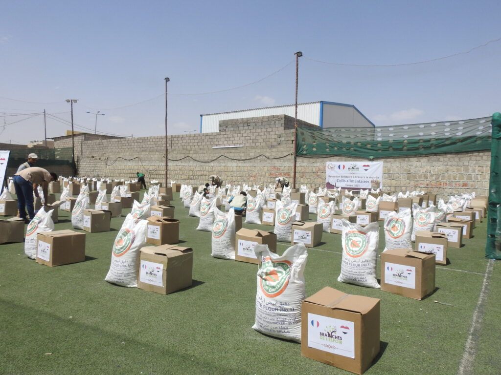 Colis alimentaires et sacs de farine alignés avant distribution