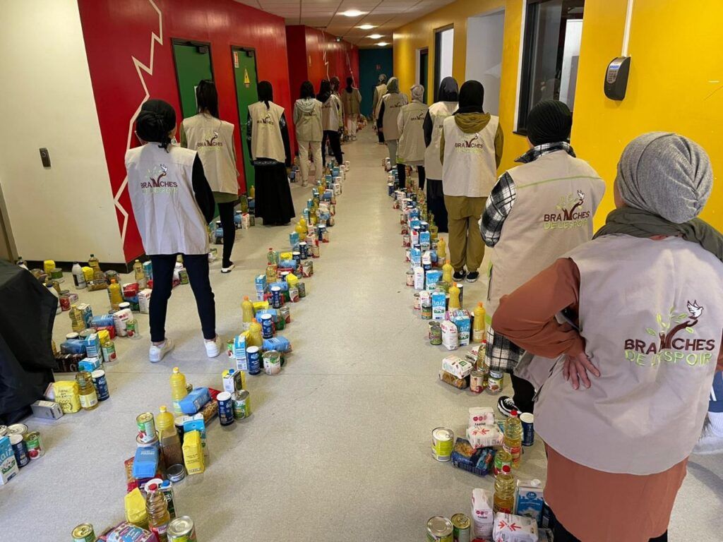 Bénévoles préparant des rangées de denrées dans un couloir