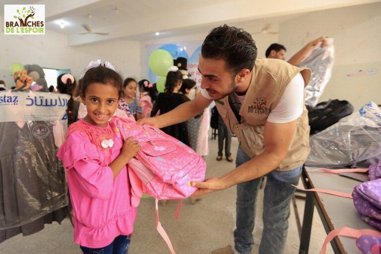 Remise de fournitures scolaires à une enfant